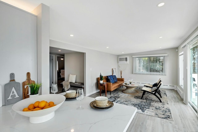 dining area featuring an AC wall unit, plenty of natural light, and light hardwood / wood-style floors