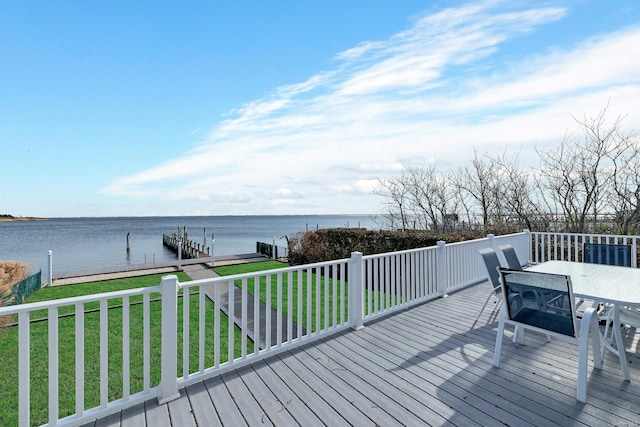 wooden deck with a water view, a yard, and a dock