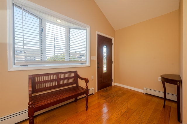 entrance foyer featuring wood-type flooring, baseboard heating, and vaulted ceiling