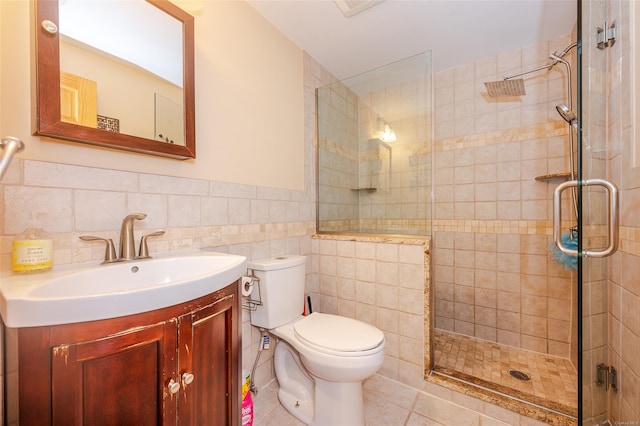 bathroom featuring tile patterned flooring, vanity, toilet, and tile walls