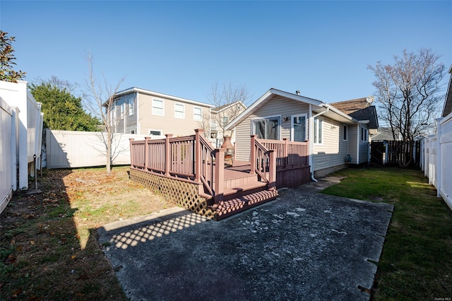 rear view of house featuring a yard and a wooden deck