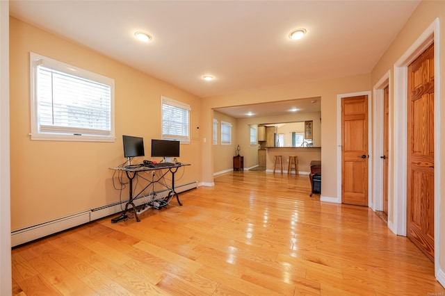 interior space featuring wood-type flooring and a baseboard heating unit