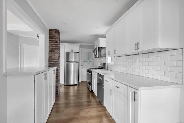 kitchen featuring stainless steel appliances, backsplash, dark hardwood / wood-style flooring, light stone countertops, and white cabinets