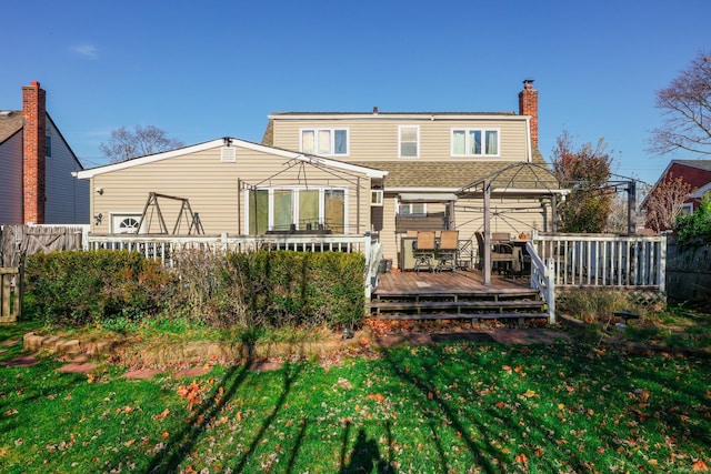 rear view of property featuring a yard and a deck