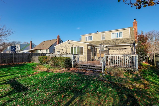 back of property with a lawn and a deck