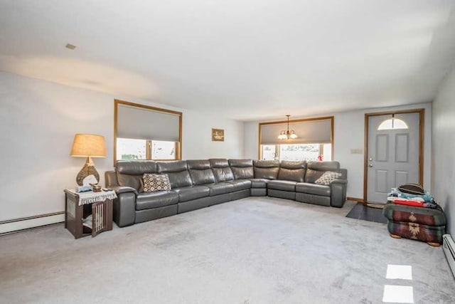 carpeted living room with a notable chandelier and a baseboard heating unit