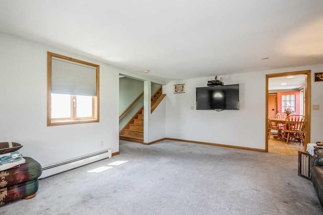 living room featuring plenty of natural light, baseboard heating, and light carpet