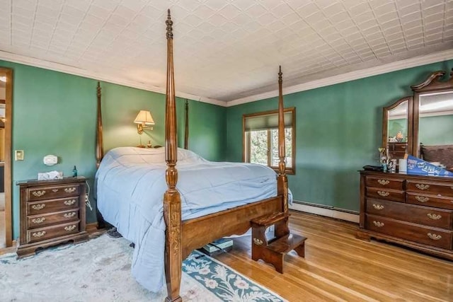 bedroom featuring light hardwood / wood-style floors, crown molding, and baseboard heating