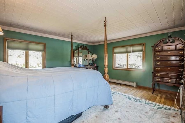 bedroom with baseboard heating, multiple windows, ornamental molding, and hardwood / wood-style flooring