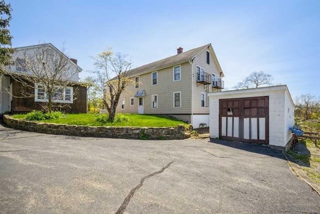 view of property exterior featuring a lawn and a balcony