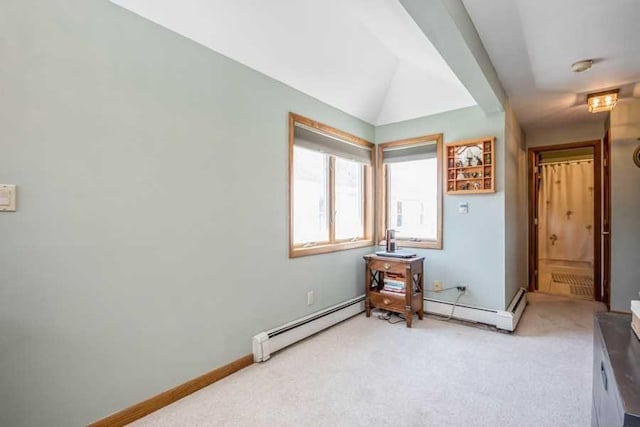 carpeted bedroom featuring lofted ceiling and a baseboard heating unit