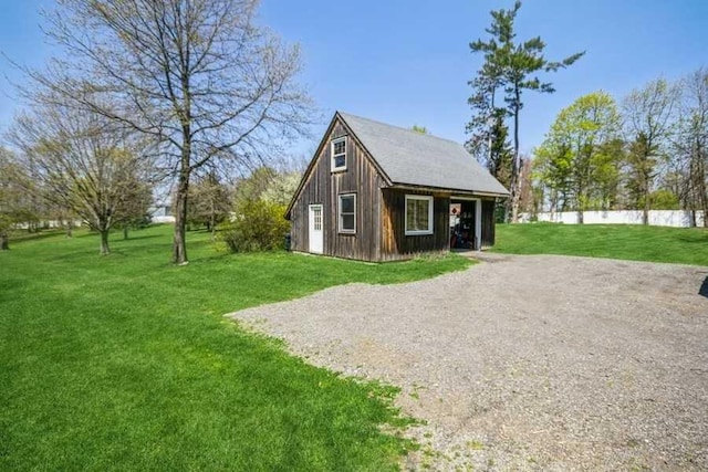 view of side of property with a lawn and an outbuilding