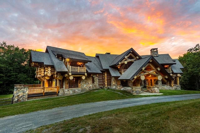 log-style house featuring a yard and a balcony