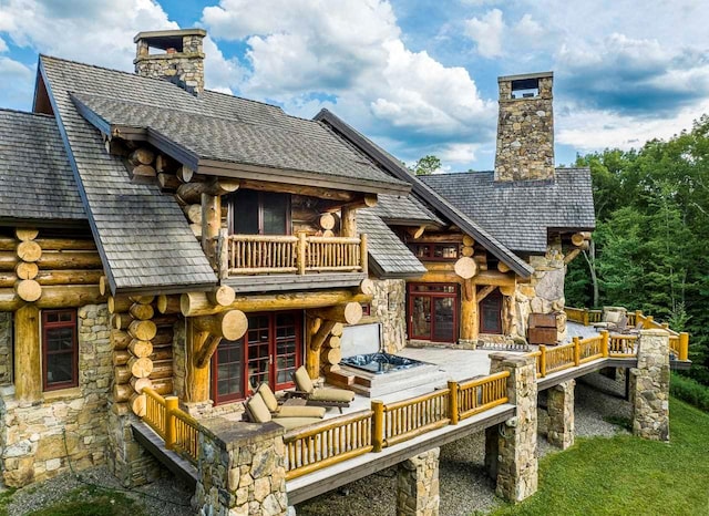 rear view of property featuring french doors and a balcony