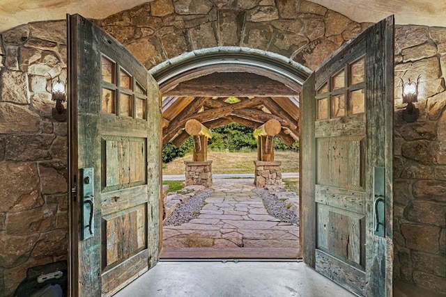 entryway featuring lofted ceiling with beams and concrete floors