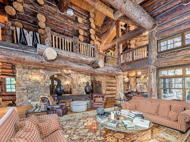 living room with wood-type flooring, a high ceiling, and log walls