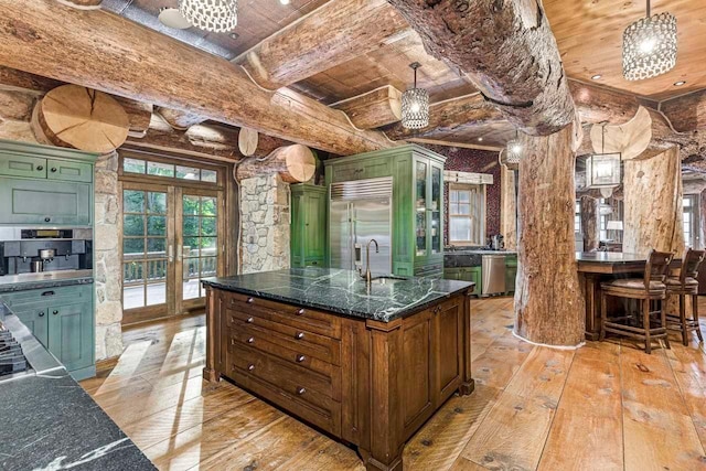 kitchen featuring pendant lighting, light wood-type flooring, french doors, and green cabinetry