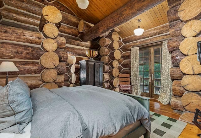 unfurnished bedroom with hardwood / wood-style floors, vaulted ceiling with beams, rustic walls, and wooden ceiling