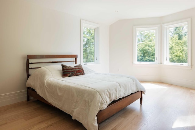 bedroom featuring light hardwood / wood-style floors and vaulted ceiling