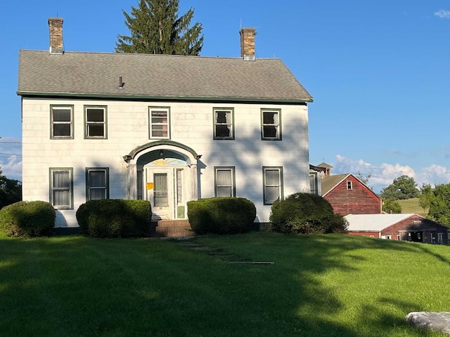 colonial-style house with a front lawn