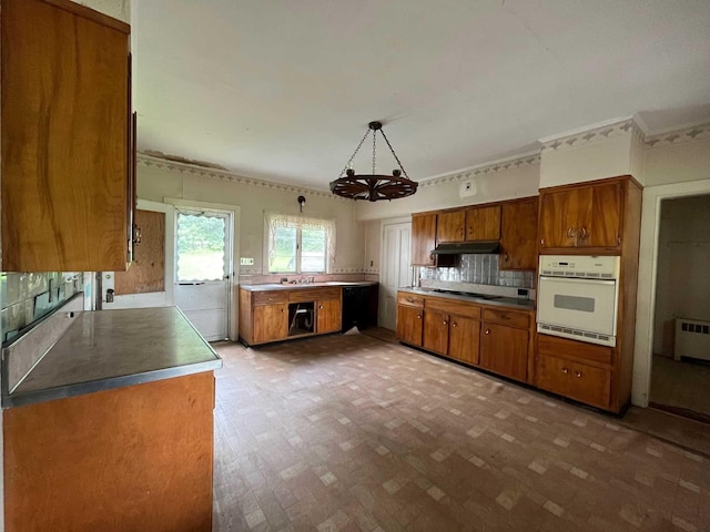 kitchen featuring radiator, white oven, black electric stovetop, decorative backsplash, and decorative light fixtures