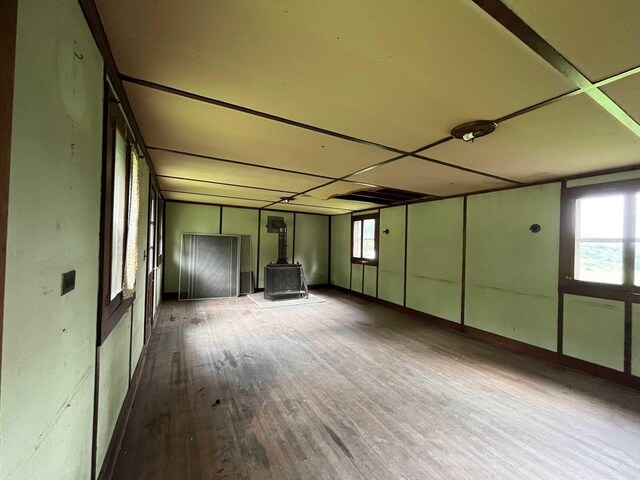 interior space with wood-type flooring and a wood stove