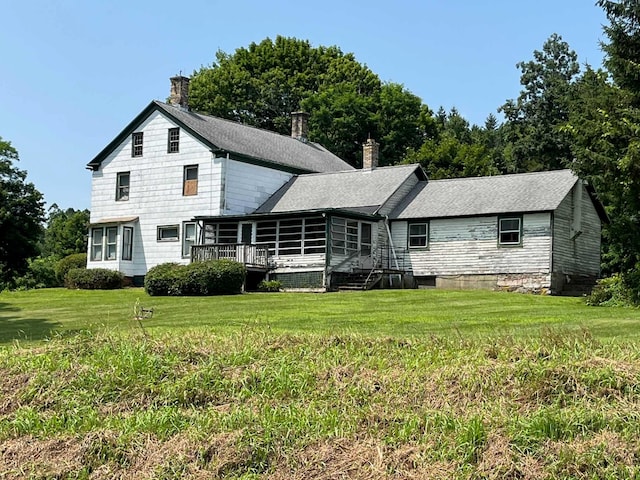 rear view of house with a deck and a lawn