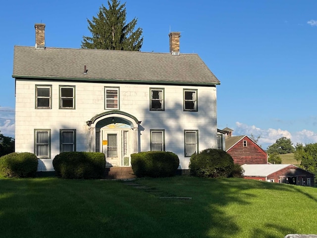 colonial inspired home with a front lawn