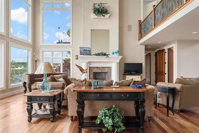 living room with light hardwood / wood-style flooring and a towering ceiling