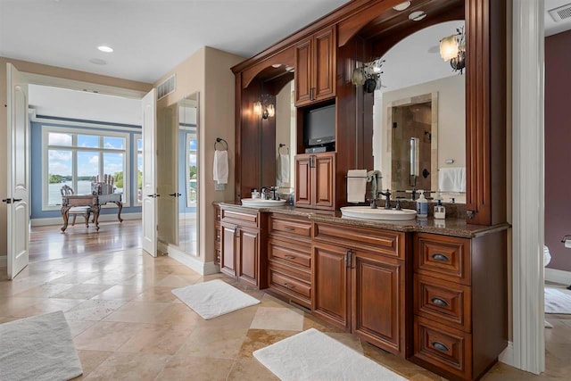 bathroom with an enclosed shower, double sink, tile floors, and vanity with extensive cabinet space