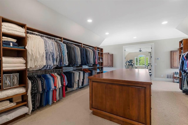 walk in closet with ceiling fan, lofted ceiling, and light colored carpet