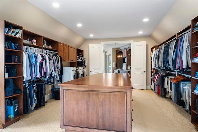 walk in closet featuring lofted ceiling, light colored carpet, and washer and clothes dryer