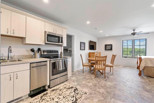 kitchen with stainless steel appliances, recessed lighting, light countertops, and a sink