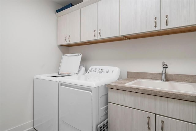 laundry area featuring independent washer and dryer, a sink, and cabinet space