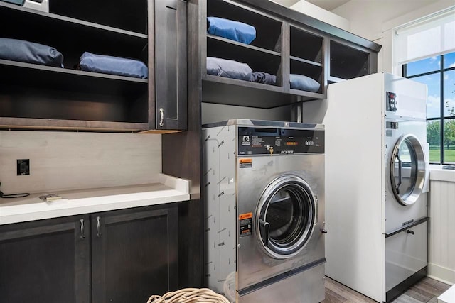 laundry room with light wood-style flooring, cabinet space, and washer / dryer