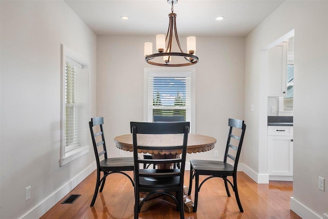 dining area with light wood-type flooring, visible vents, recessed lighting, a chandelier, and baseboards