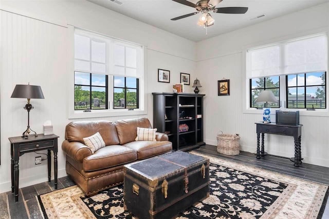 living room featuring a wealth of natural light, baseboards, a ceiling fan, and wood finished floors