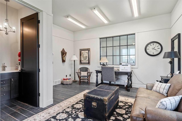 living area with dark wood-type flooring, a chandelier, baseboards, and visible vents