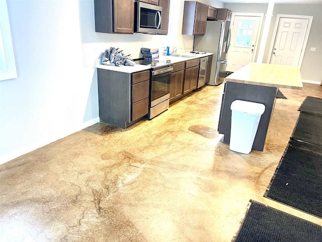 kitchen featuring sink, stainless steel appliances, and dark brown cabinets