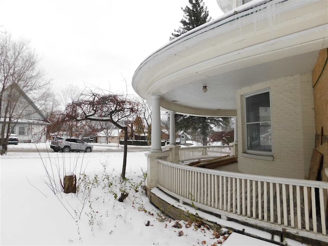 yard covered in snow with covered porch