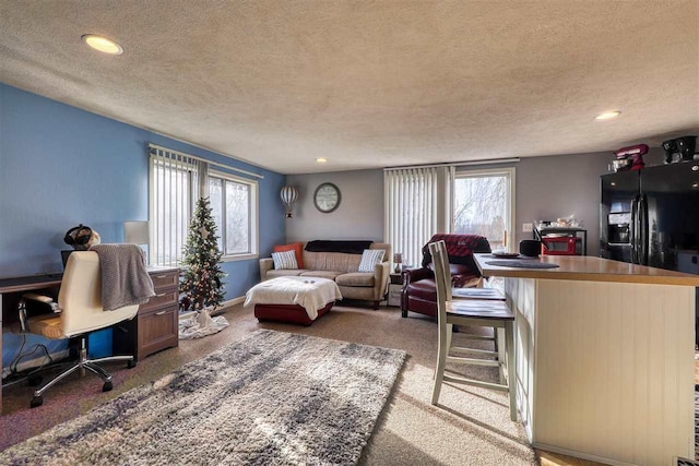 living room featuring carpet flooring, a wealth of natural light, and a textured ceiling