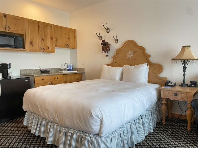 bedroom featuring sink and dark carpet