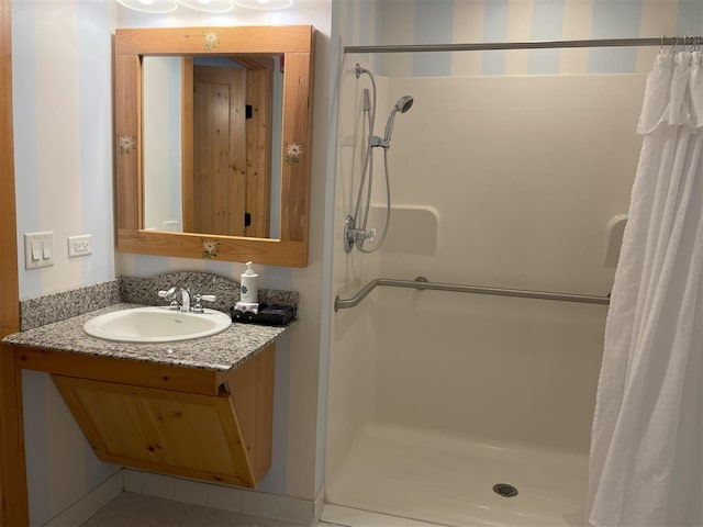 bathroom with tile floors, vanity, and walk in shower