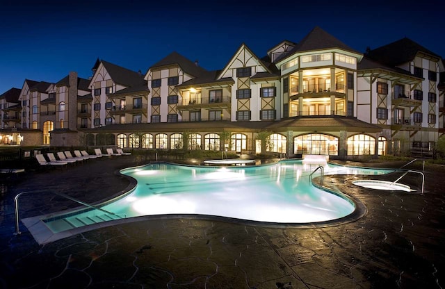 pool at night with a patio area