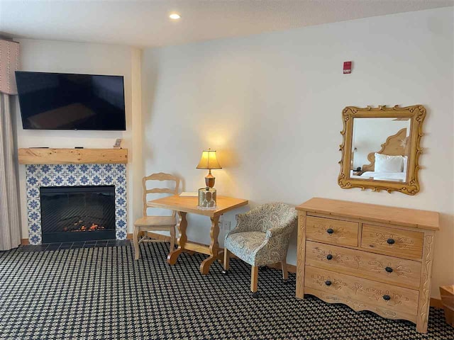 interior space featuring dark carpet and a tile fireplace