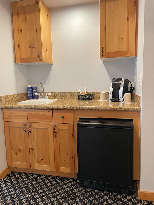 kitchen featuring light stone countertops and sink