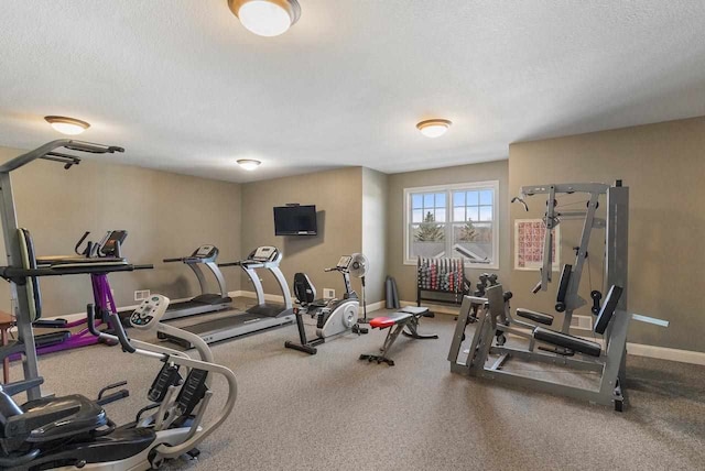 workout area with carpet flooring and a textured ceiling