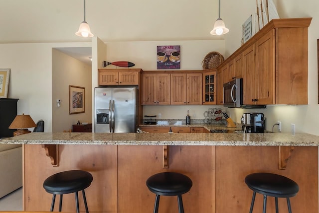 kitchen with a kitchen bar, hanging light fixtures, and stainless steel appliances