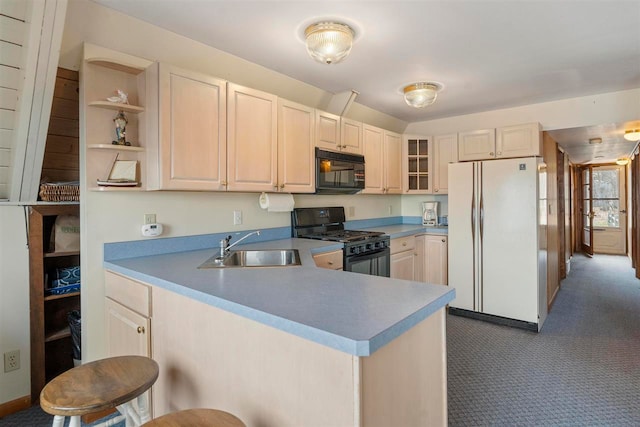 kitchen with a kitchen breakfast bar, kitchen peninsula, black appliances, dark colored carpet, and sink