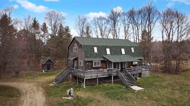 rear view of house with a wooden deck and a yard